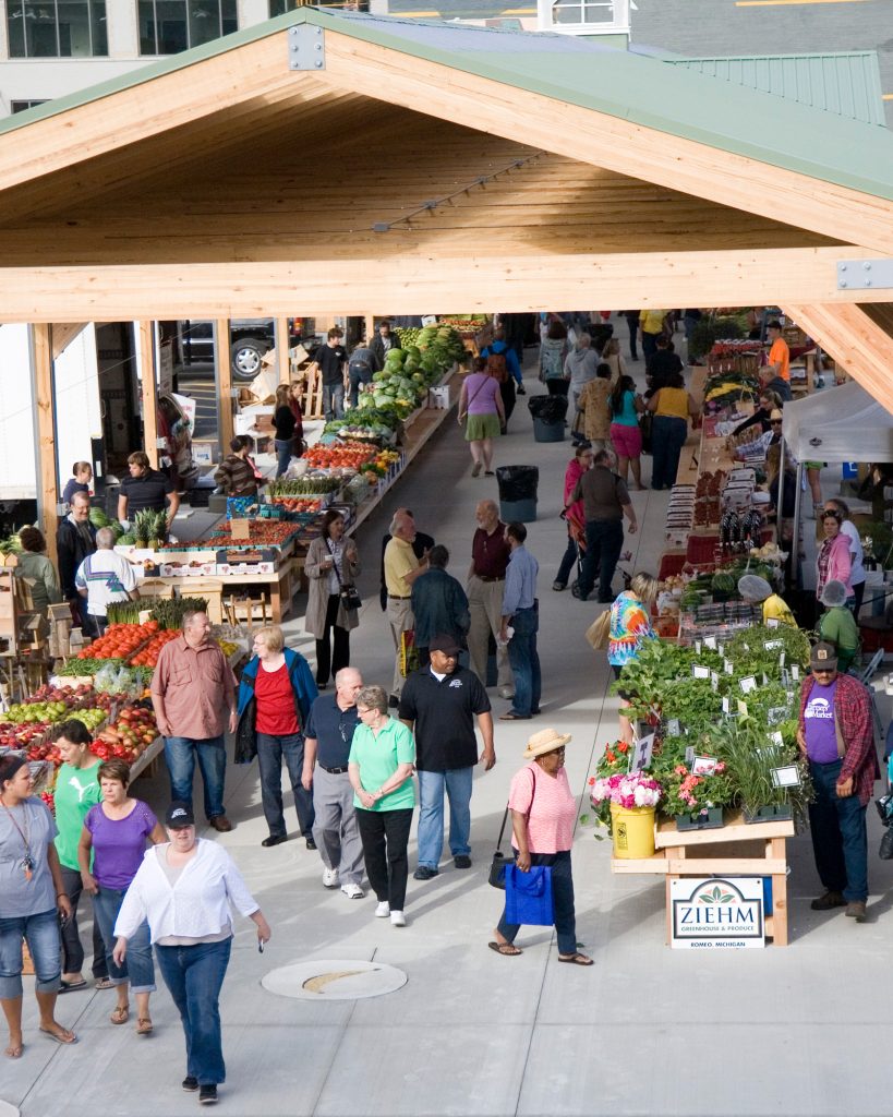 The outside pavilion at the Flint Farmers' Market is filled with shoppers and vendors.